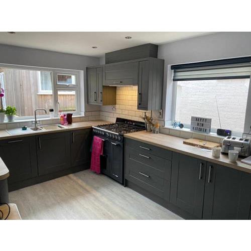 Dark grey fitted kitchen with wood laminate worktops and black range cooker 500x500