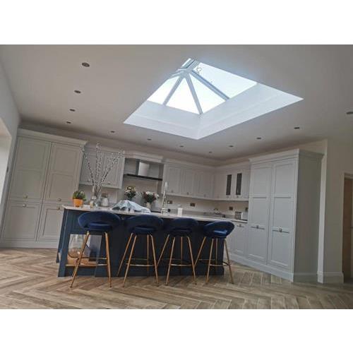 Fitted kitchen with cream coloured cabinets navy blue island and large roof light 500x500