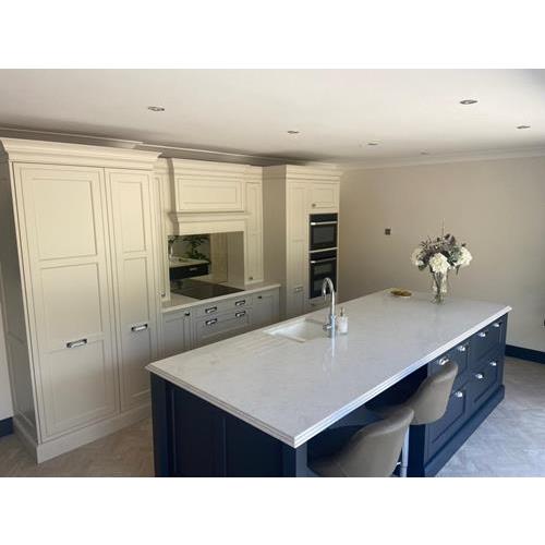 Fitted kitchen with full-height cream cabinets and dark blue kitchen island with quartz worktop 500x500