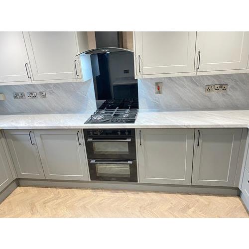 Fitted kitchen with grey cabinets and marble worktops and full height splashbacks 500x500