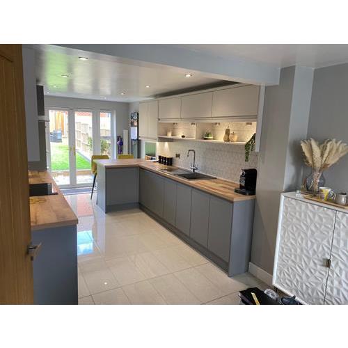 Fitted kitchen with modern grey cabinets and wood laminate worktops bifold doors to garden 500x500