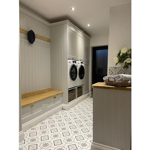 Fitted utility room with light grey cabinets storage bench and built in washing machine and dryer 500x500