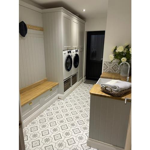 Fitted utility room with light grey cabinets storage bench and patterned tiled floor 500x500