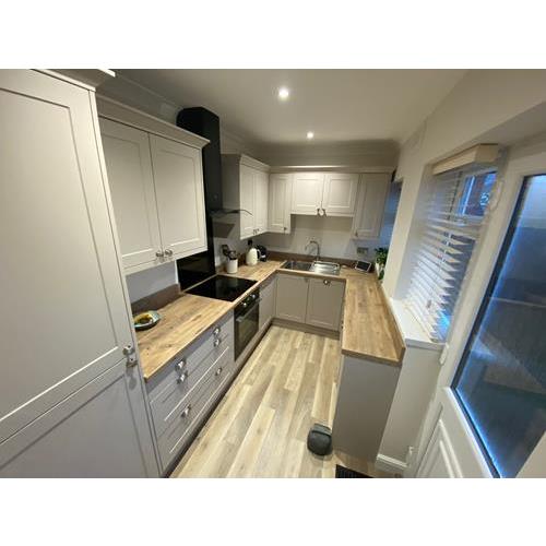Galley kitchen with light cabinets and laminate wood worktops and flooring 500x500