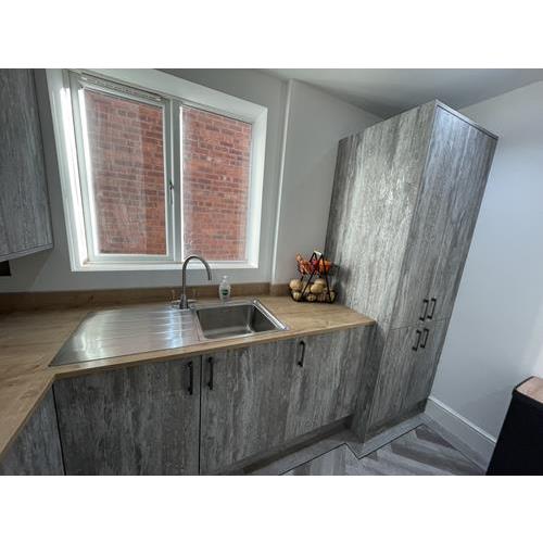 Grey kitchen cabinets with laminate wood worktops and stainless steel sink 500x500