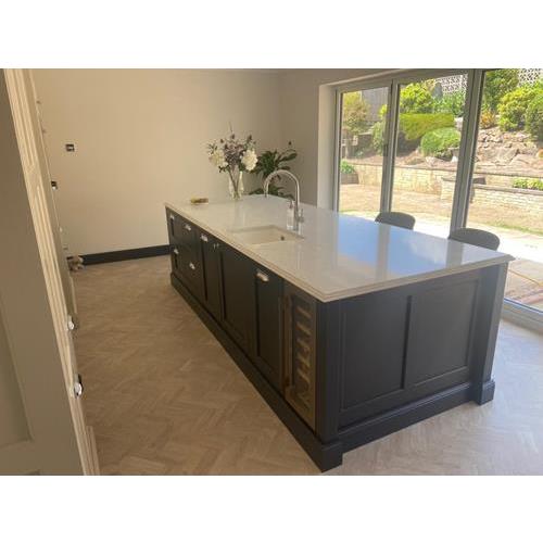 Large kitchen island with dark blue base and white quartz worktop with fitted sink 500x500