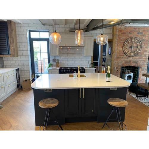 Large kitchen island with navy cabinets white worktop and metro tiled walls 500x500