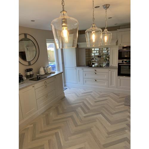 Shaker style fitted kitchen with grey cabinets and grey herringbone wood floor 500x500